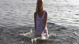 Young blonde splashes in the water